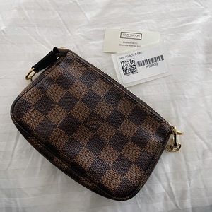 Authentic Louis Vuitton damier ebene mini pochette with red canvas interior.